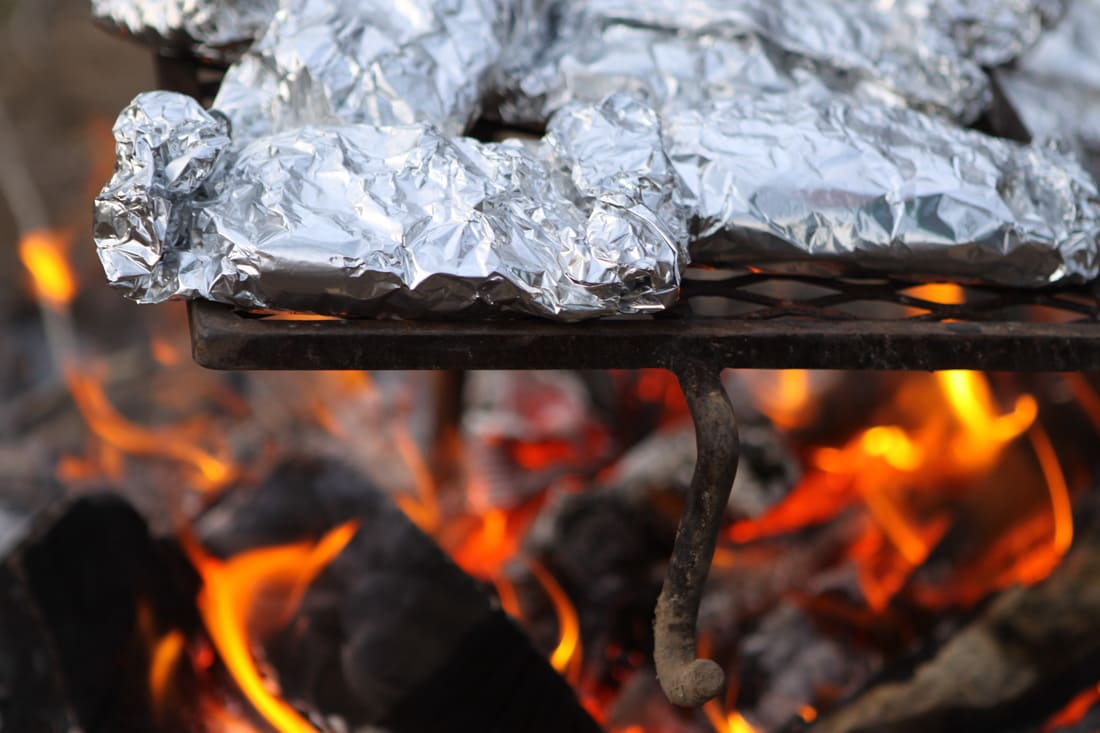 Food wrapped in tinfoil on a fire