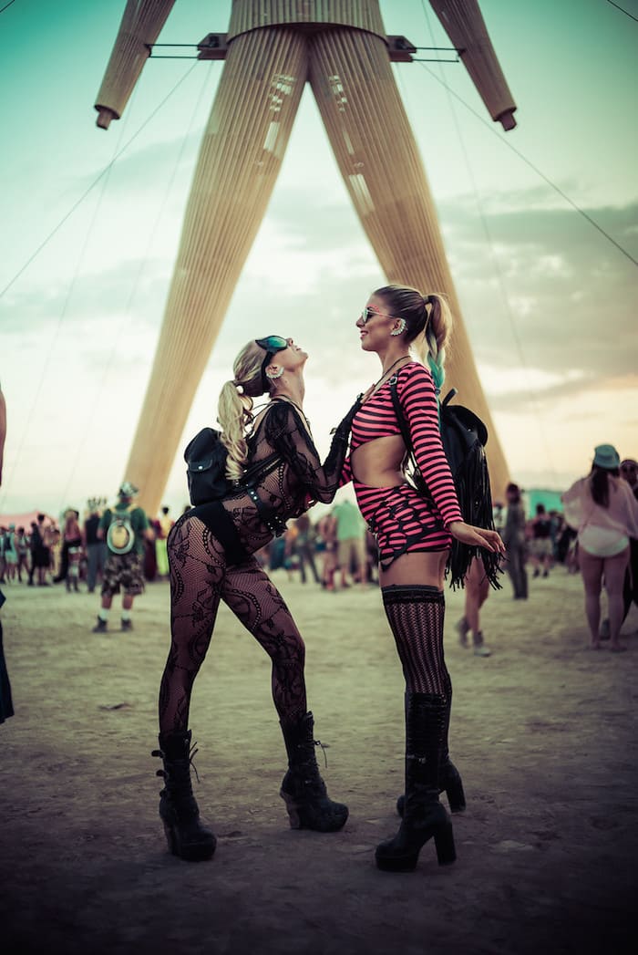 Two girls posing and facing each other at Burning Man