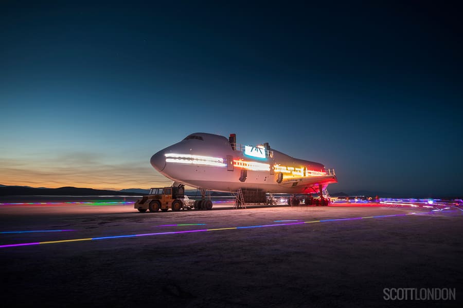 Airplane on the beach surrounded by neon lights