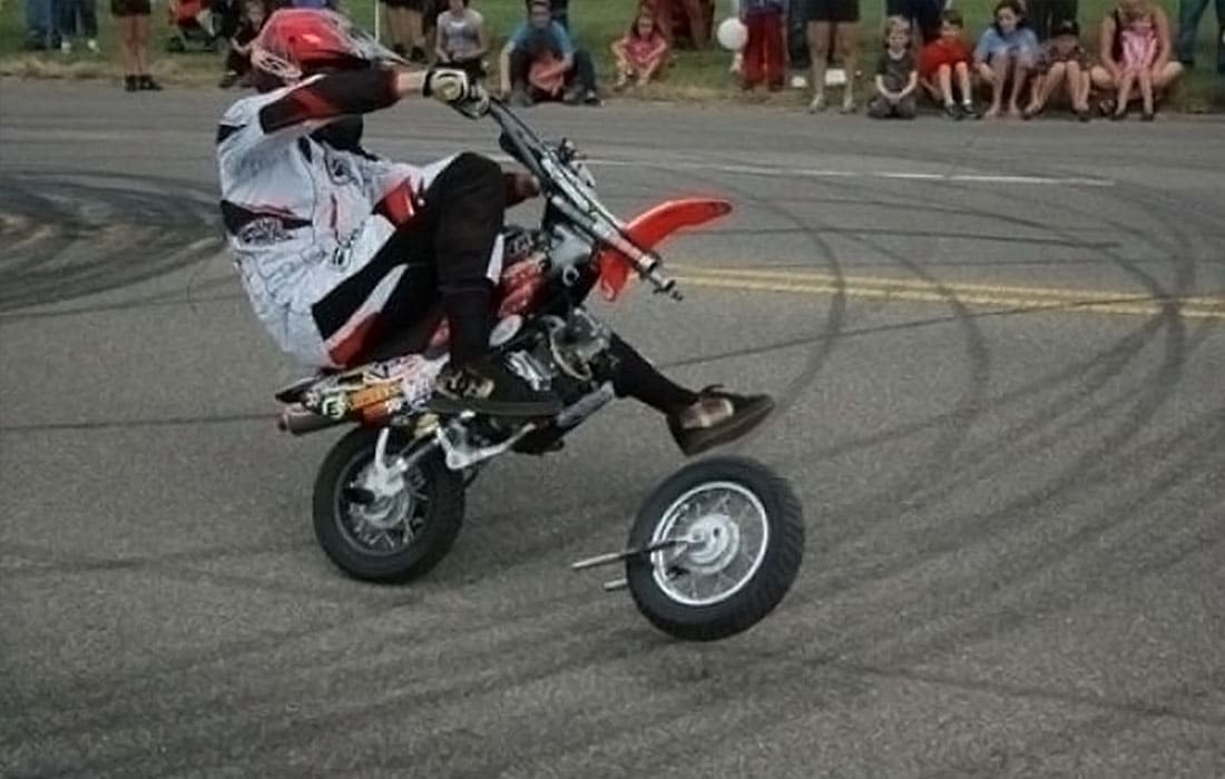 A man driving a motorbike with a wheel coming off 