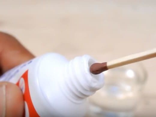 a match being about to be dipped into a tube of toothpaste