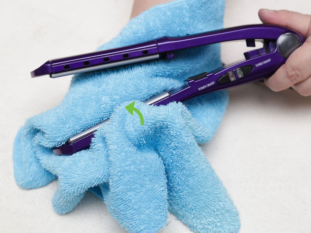 cleaning hair straightener with soft cloth.