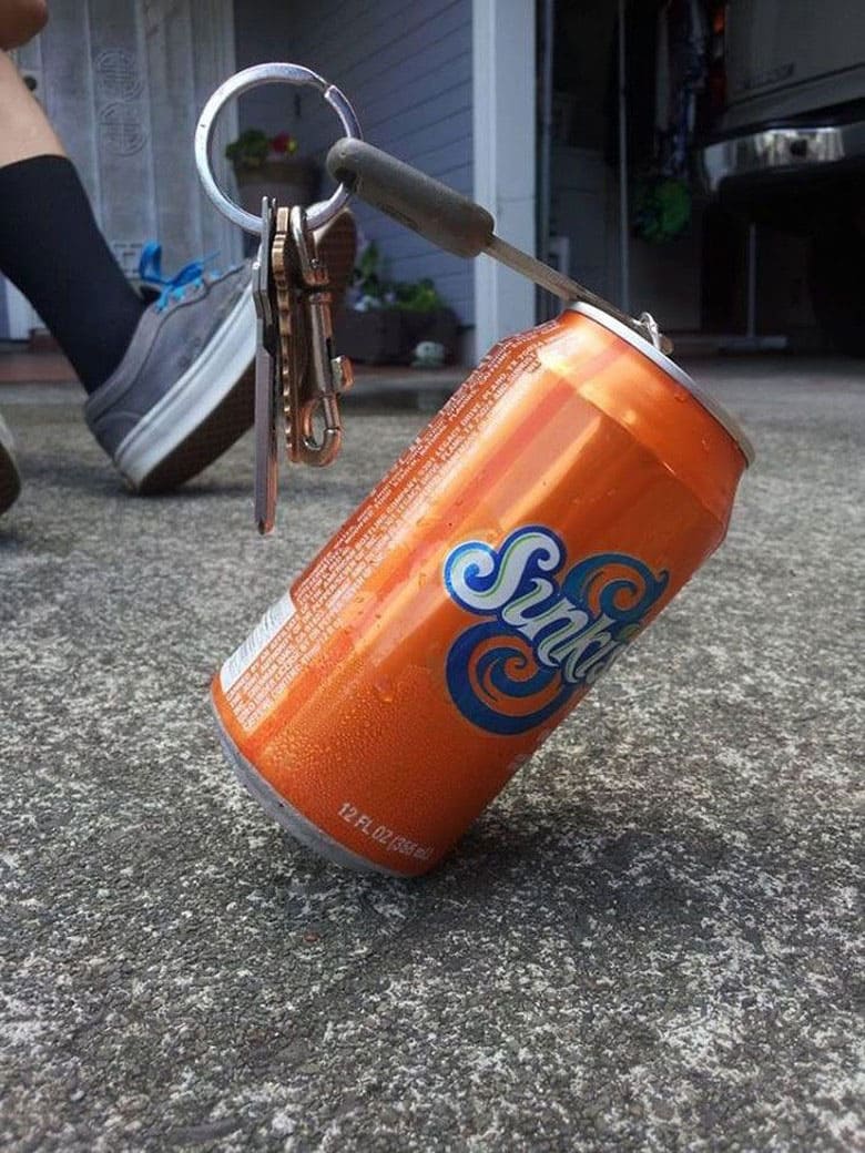 A set of car keys and an empty soda can balance on one another