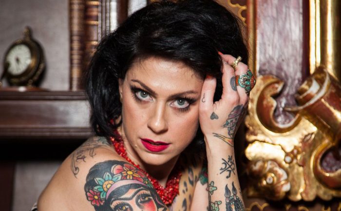 Danielle Colby leaning on a fancy chair 