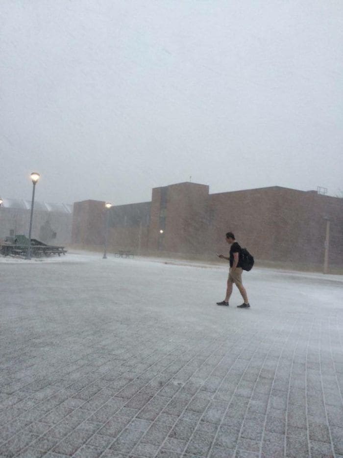 Man walking in a snowstorm wearing shorts and t-shirt