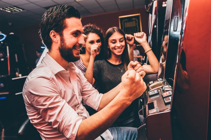 Group of friends playing slot machines