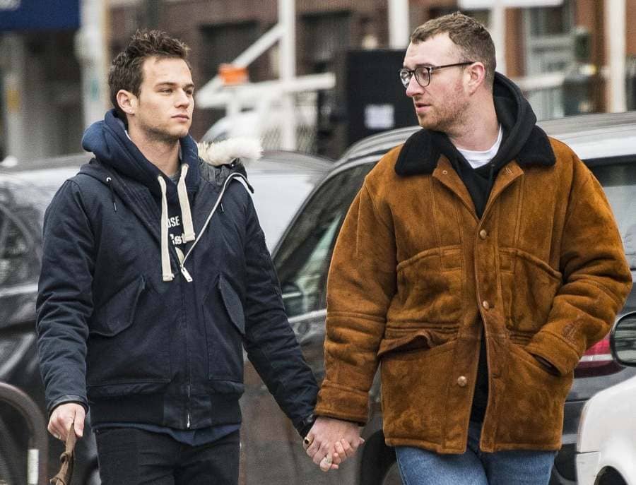 Paparazzi photograph of Sam Smith and Brandon Flynn walking the dog and holding hands. 