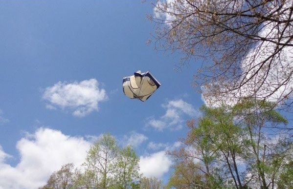 tent flying in the air by the trees