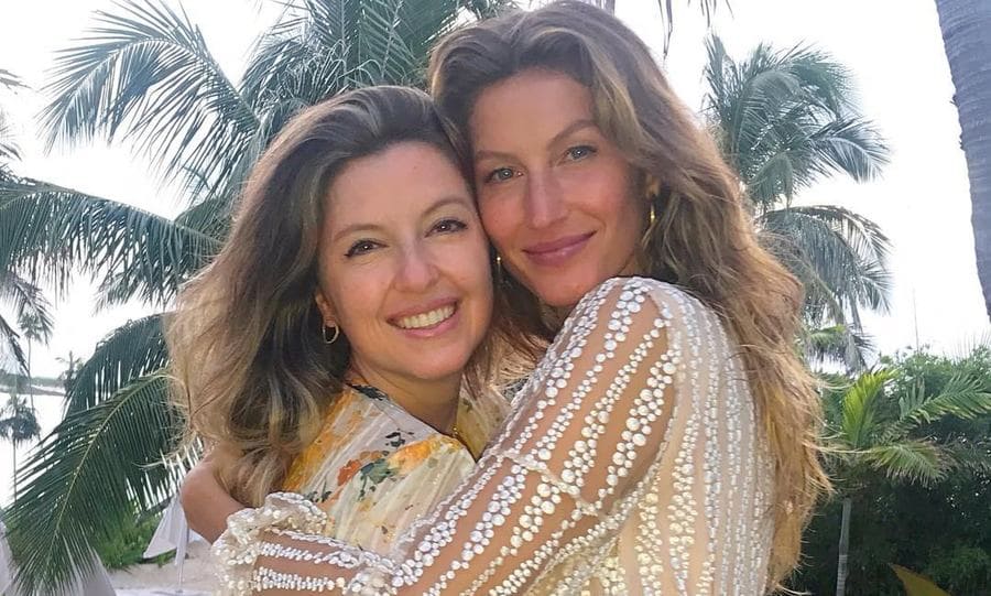 Gisele and Patricia Bundchen posing together with a book. 