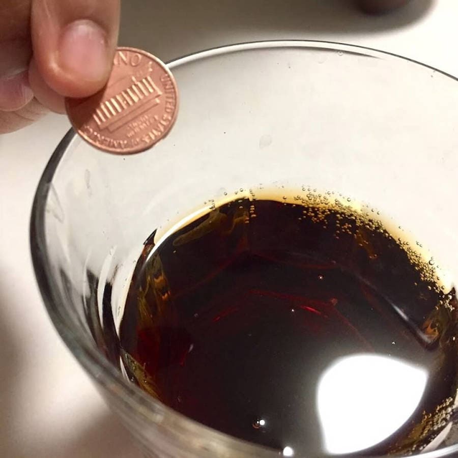 A coin and a glass of Coke