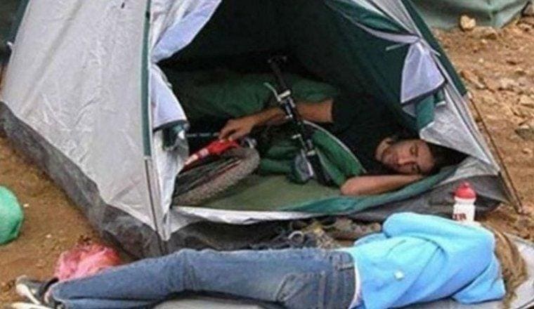 man hugging his bike inside a tent while girlfriend is lying on the ground