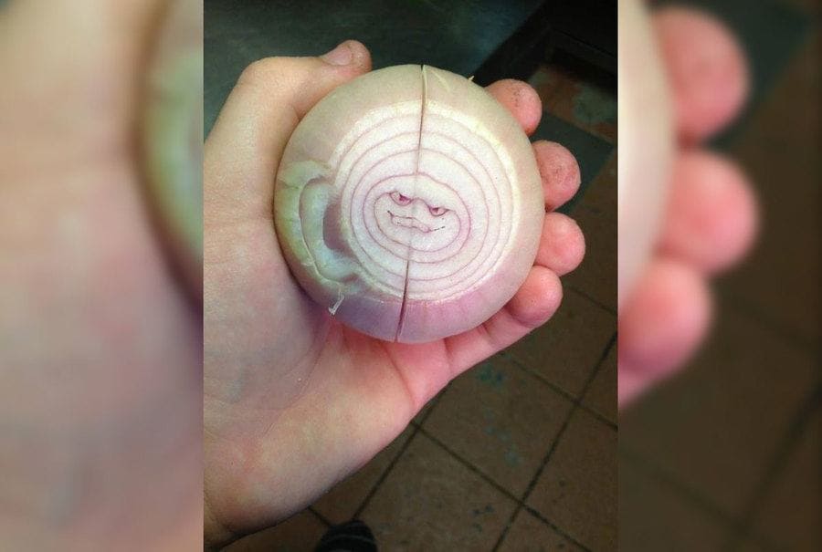An evil-looking smiley face inside an onion 