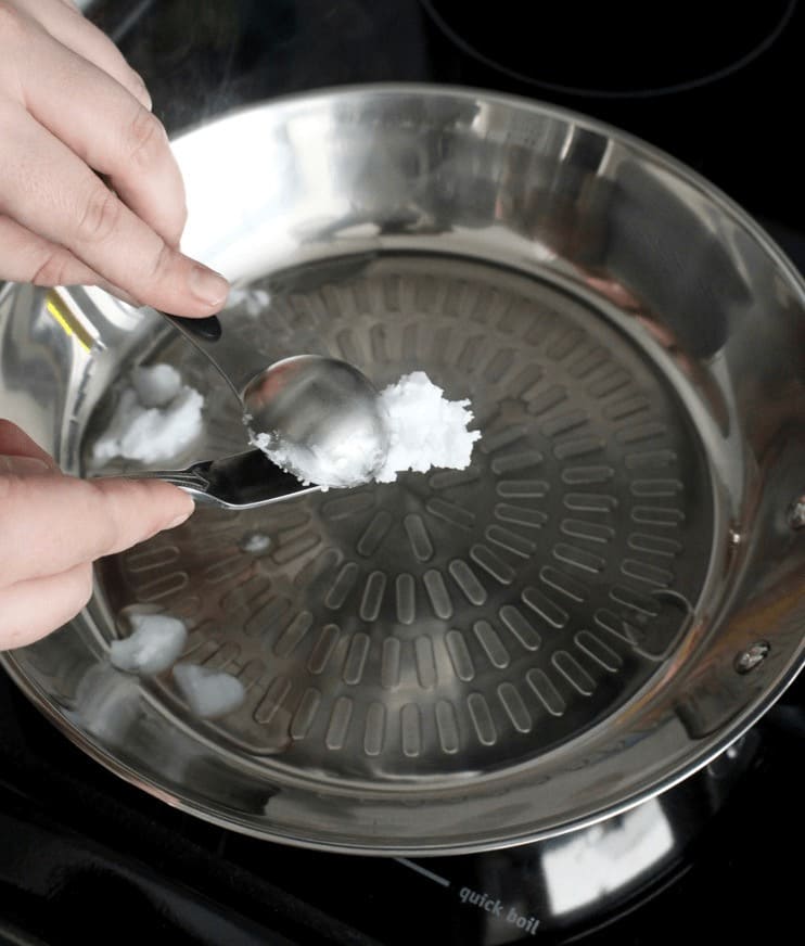 Placing salt on a pan to keep food from sticking. 