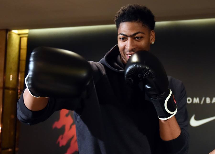 Anthony Davis with boxing gloves on learning boxing at a media event. 