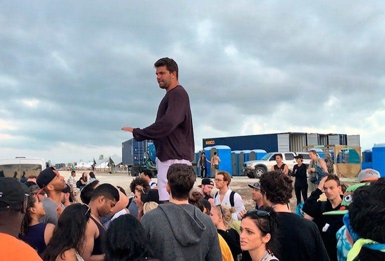 Billy McFarland standing above Fyre Festival attendees 