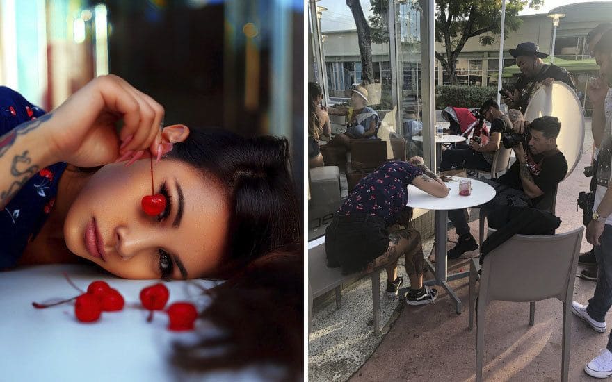 A girl with a cherry covering her eye/ someone taking a photo of a girl with her head down on a table