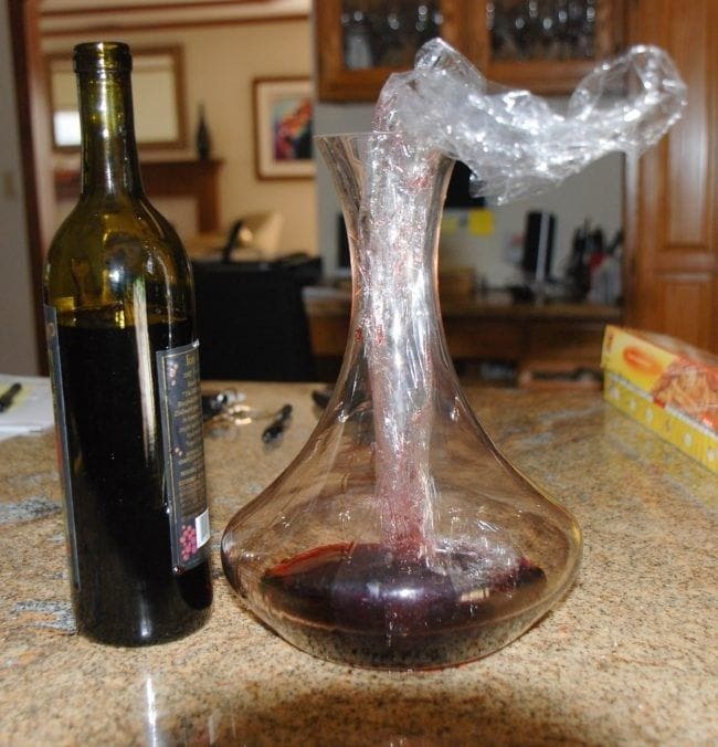 Bottle of wind and plastic wrap in a decanter 