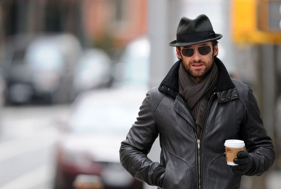 Hugh Jackman was walking around with a small cup of coffee. 