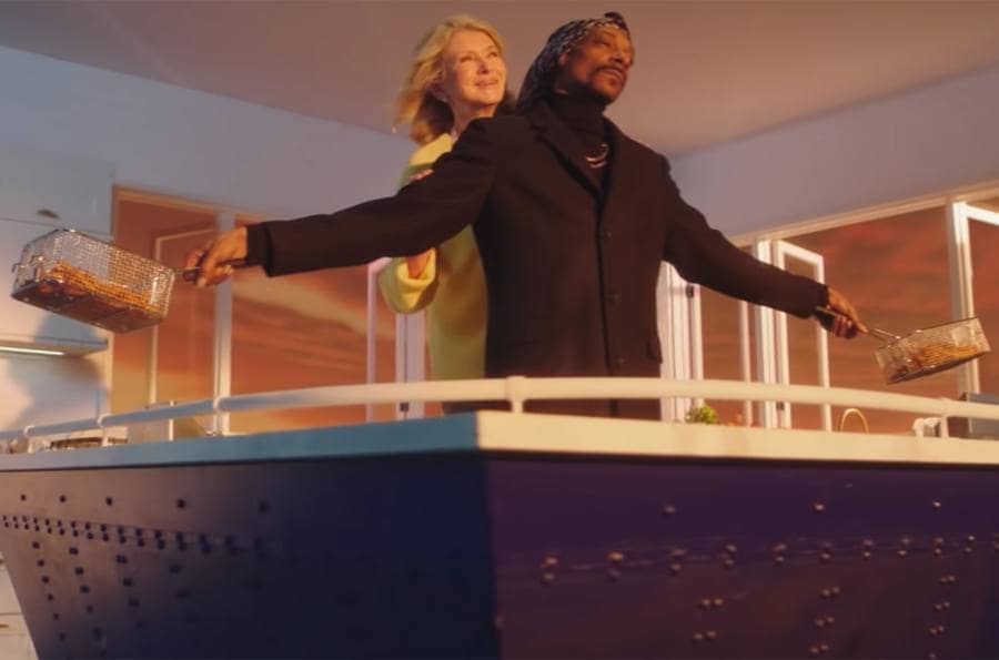 Martha and Snoop recreating the scene from the movie Titanic with them holding their arms out at the end of a boat. 