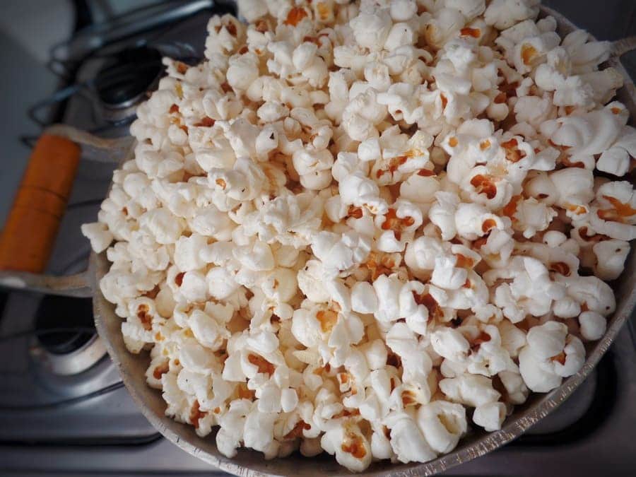 A close-up photo of popcorn popped in a pot on a four-burner stove. 