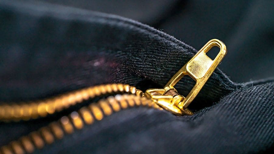 Close up Black jeans material and gold zipper macro photography on blur background 