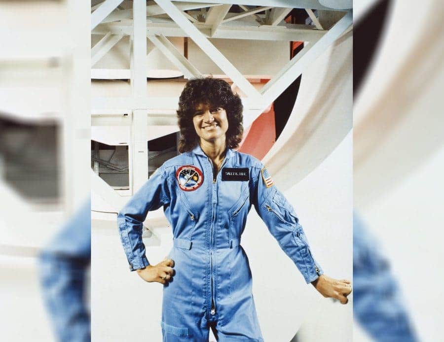 Sally Ride standing outside the shuttle mission simulator at the Johnson Space Center in 1983 wearing her uniform.