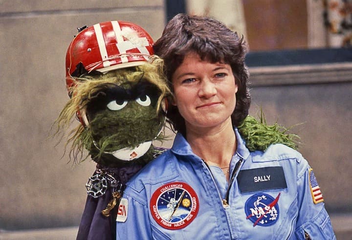 Sally Ride on Sesame Street posing with a muppet. 