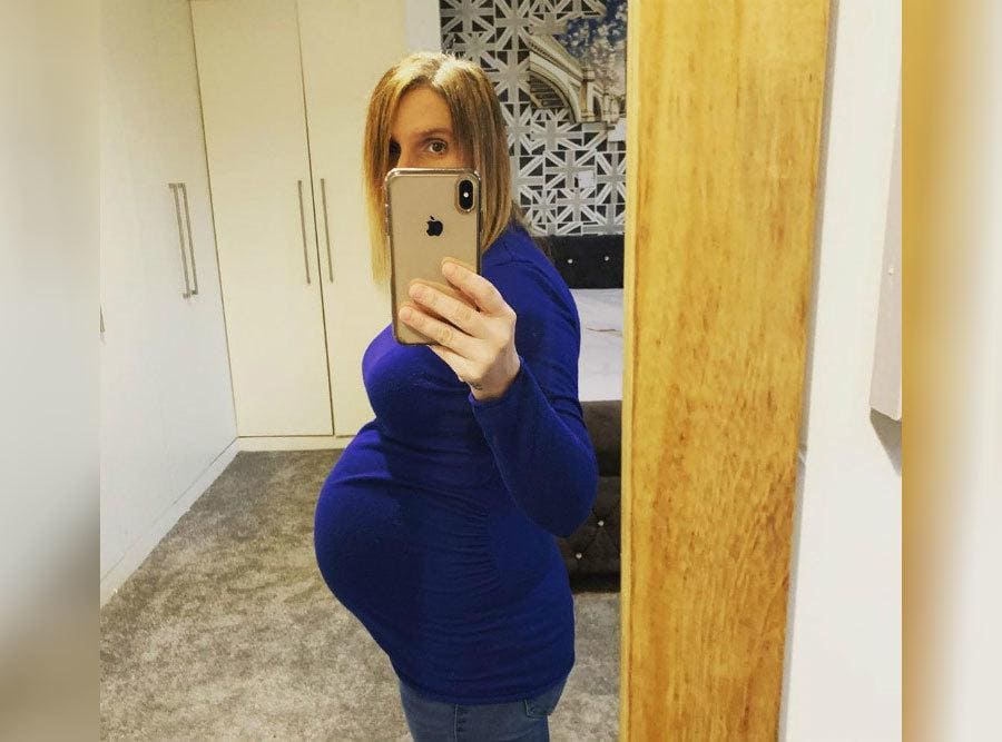 A Pregnant Sue Poses in Front of The Mirror