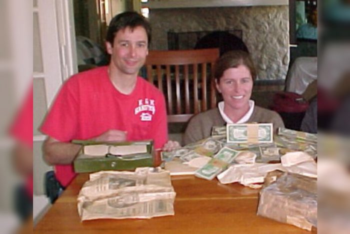 A photograph of the couple and their stacks of money sitting on the dining room table.