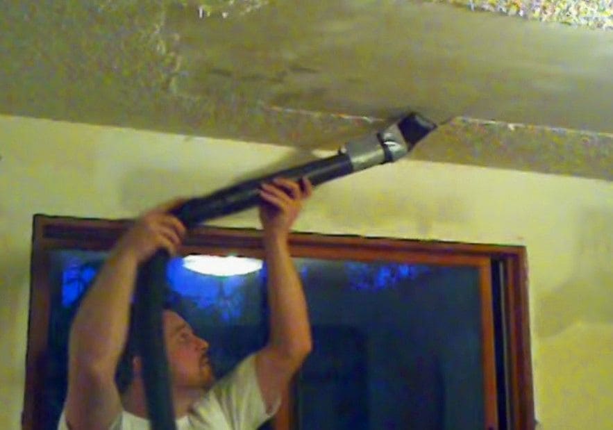 The husband was using a vacuum on the ceiling