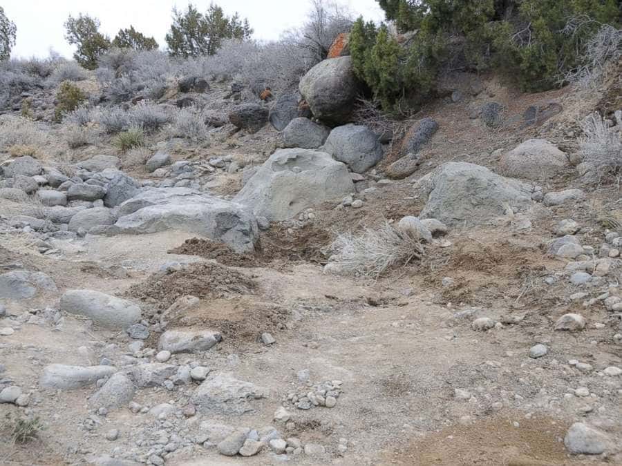 A photograph of the place where Paige was found, with rocks and dirt all around 