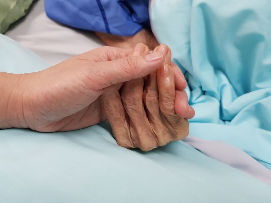 Holding a grandmother’s hand showing care