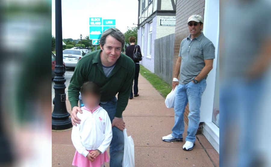 Jerry Seinfeld behind Matthew Broderick posing with a fan 