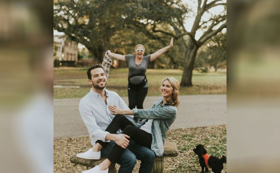 Amy Schumer posing behind a couple taking engagement photos 