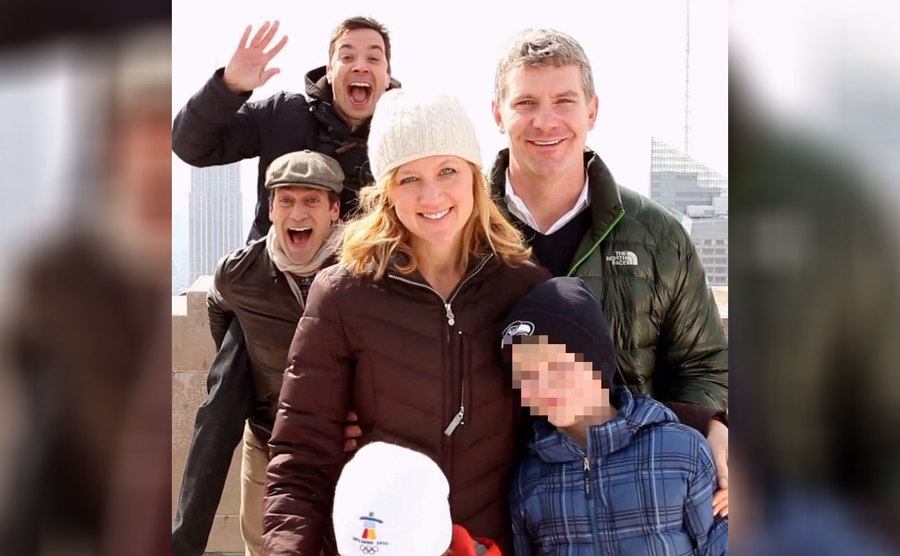Jimmy Fallon and Jon Hamm jumping into the back of a family vacation photograph 