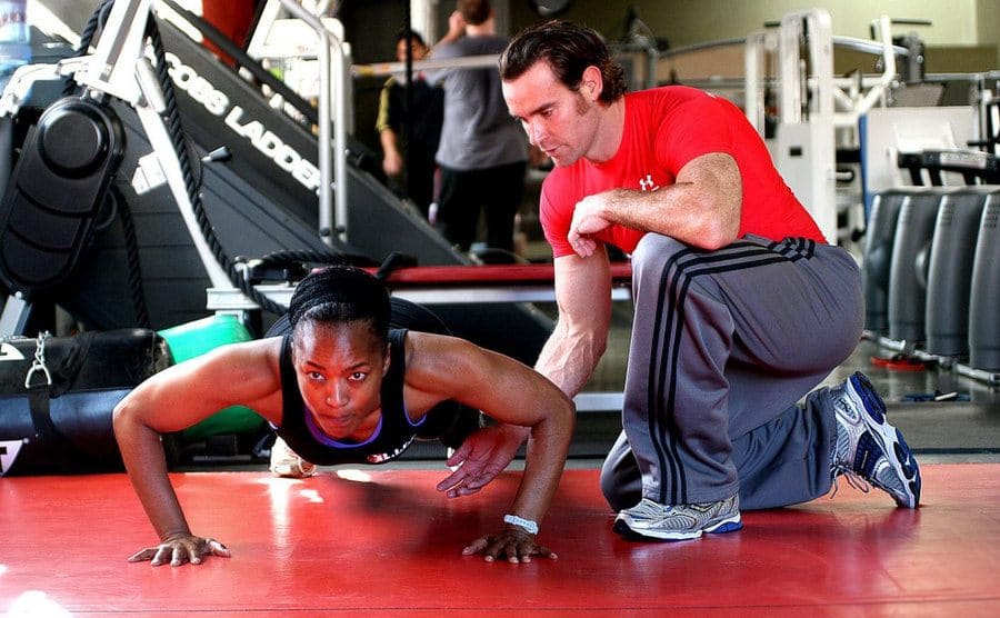 Angela Bassett and her trainer with her doing push-ups 