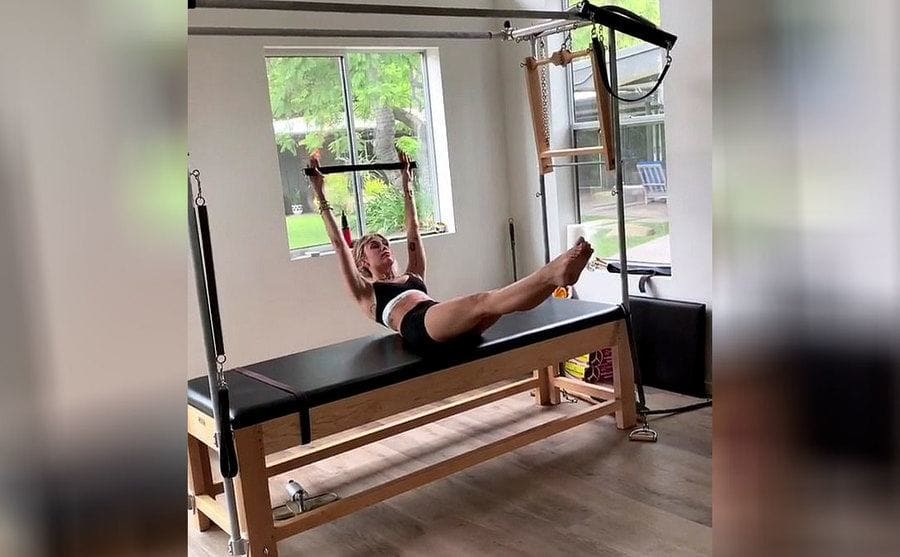 Miley Cyrus doing Pilates on a Cadillac reformer 