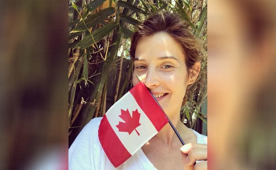 Cobie Smulders is holding a small Canadian flag 