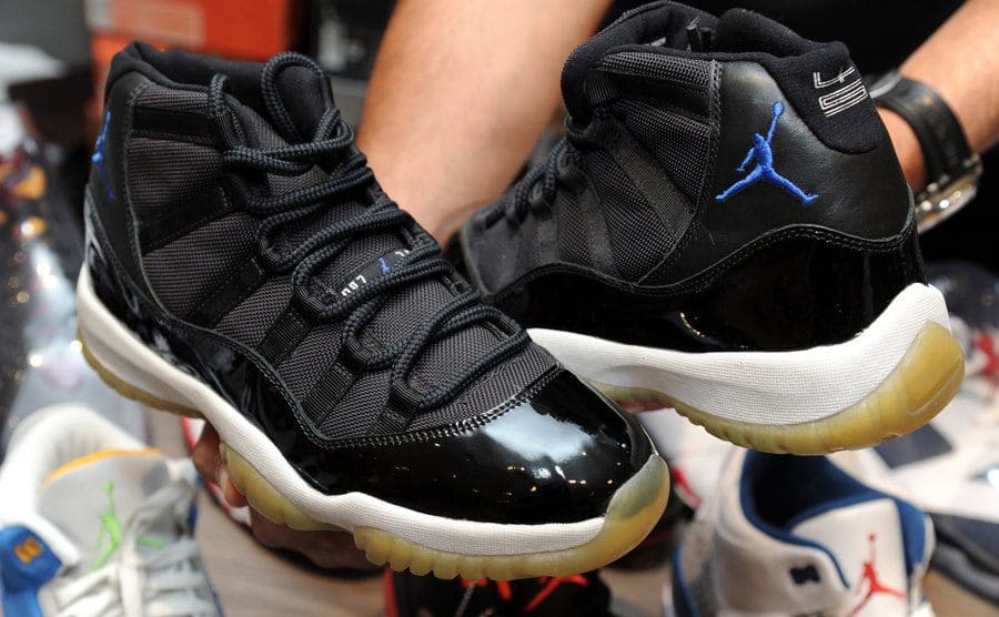 A photograph of a limited-edition pair of Air Jordan’s with a white rubber sole, black fabric and laces, and a blue logo of Jordan