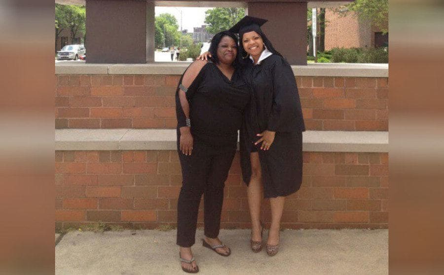 Kertisha in her graduation gown posing with her mother 