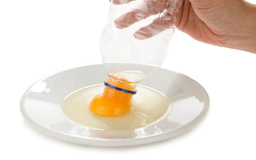 A bottle being used to suck up egg yolks