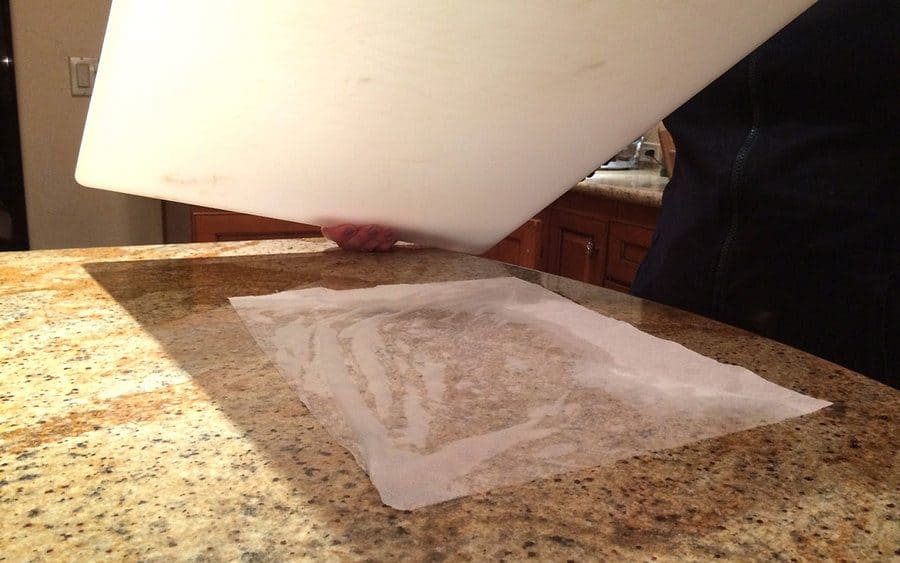 A wet paper towel placed under a chopping board