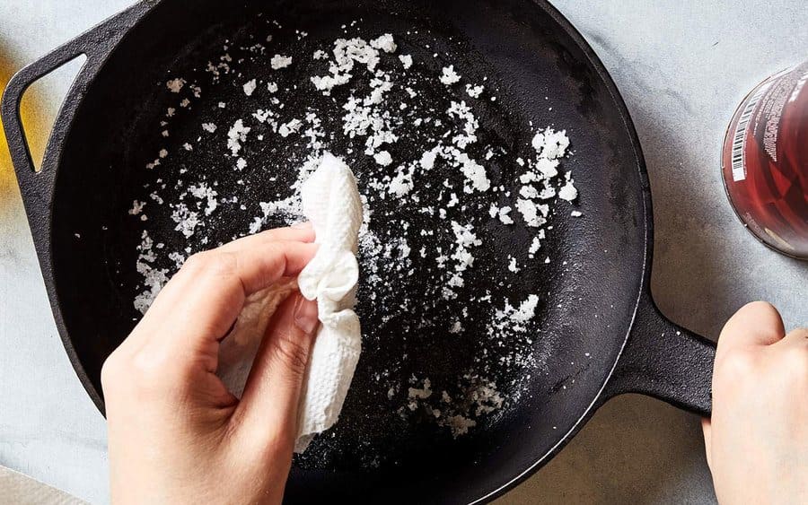 Salt being used to clean a pan