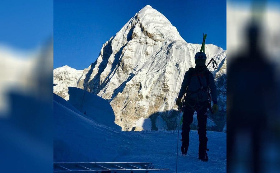 The silhouette of Willie in front of a mountain during one of their climbs 