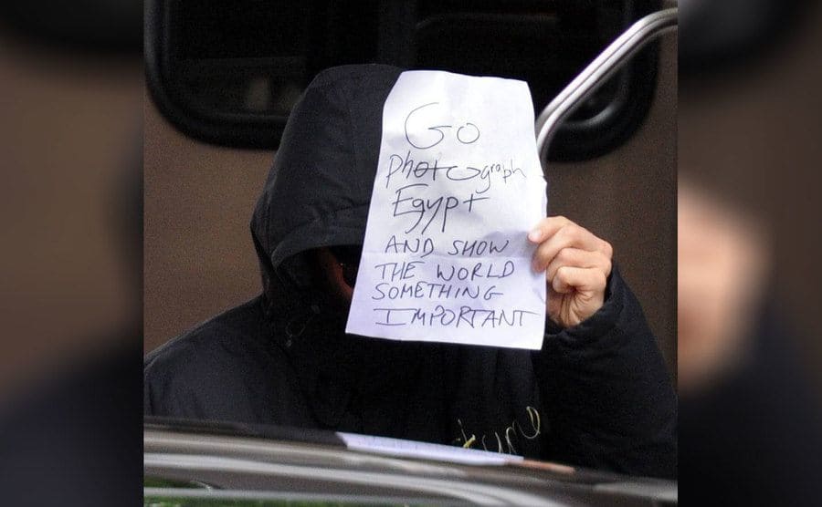 Benedict Cumberbatch holding up a sign which says, ‘Go photograph Egypt and show the world something important.’ 