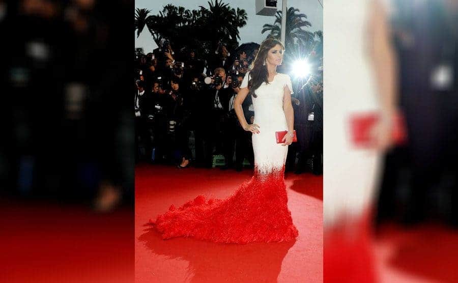Cheryl Cole in a long dress that is white until her knees and then it fades into a red feather train 