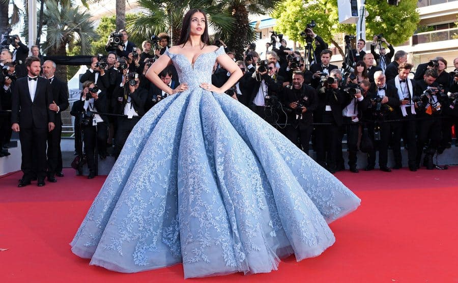 Aishwarya Rai wearing a Cinderella-style off the shoulder baby blue dress with a large puffy bottom and matching baby blue floral embroidery covering 