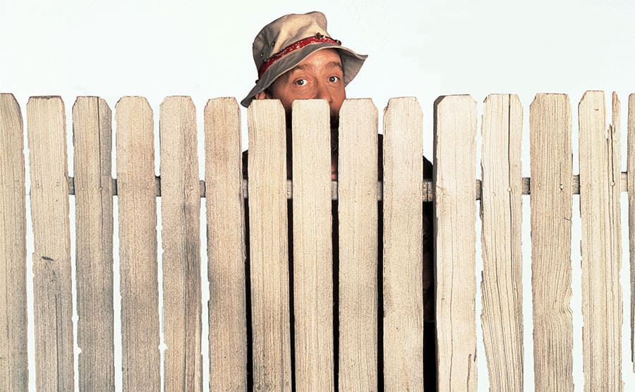 Earl Hindman behind a fence in a promotional shot for Home Improvement 