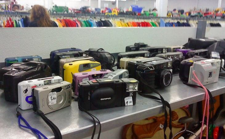 Old cameras set up on a table at goodwill 
