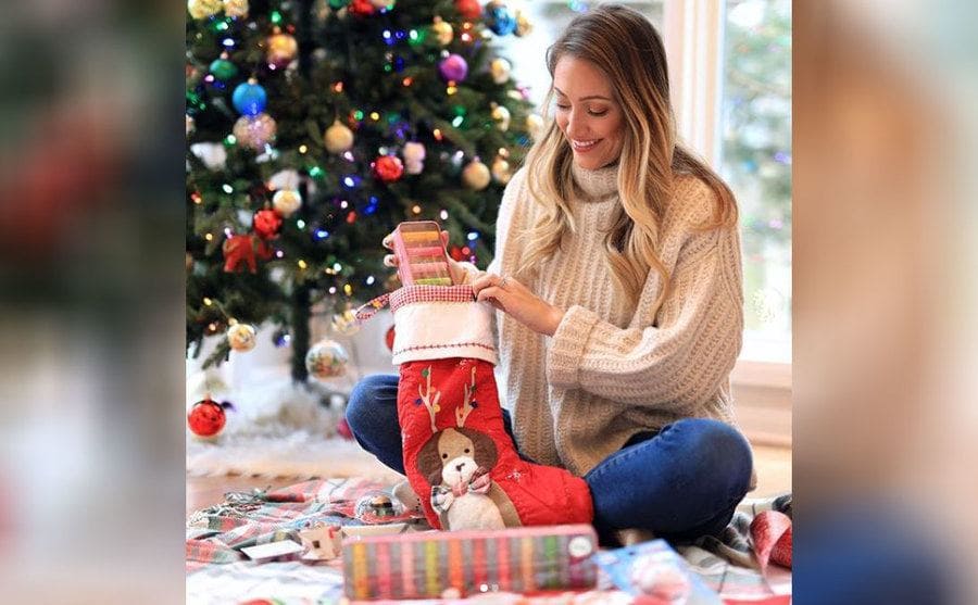 Myka putting Lipsmacker brand lip balm into Christmas stockings 